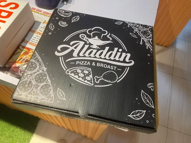 Black pizza box with the Aladdin Pizza & Broast logo.