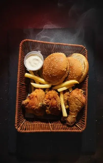 A basket of broast, buns, fries, and dip seen from above.